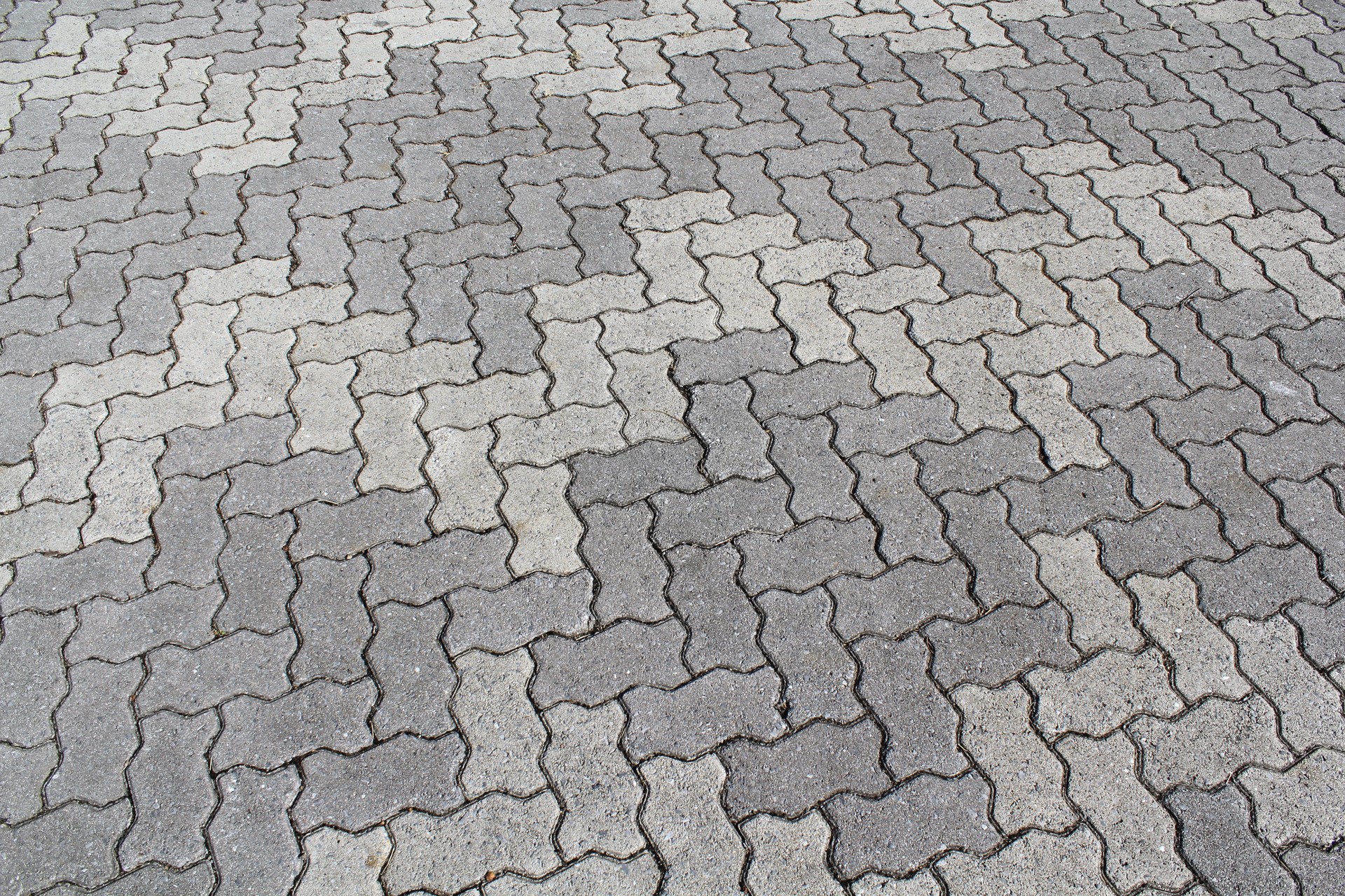 Close up of interlocking grey bricks forming a pattern in a pavement Close up of interlocking grey bricks forming a pattern in a pavement